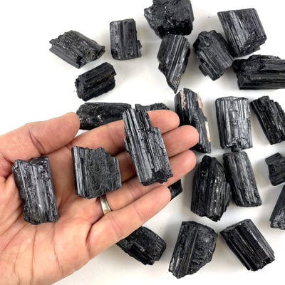 black tourmaline pendant sized rods in hand for size reference 