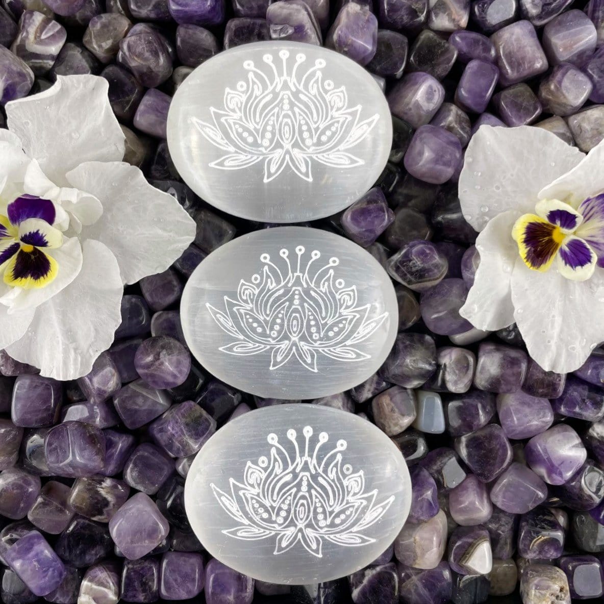 overhead view of selenite lotus engraved palm stones for engraving details and possible variations