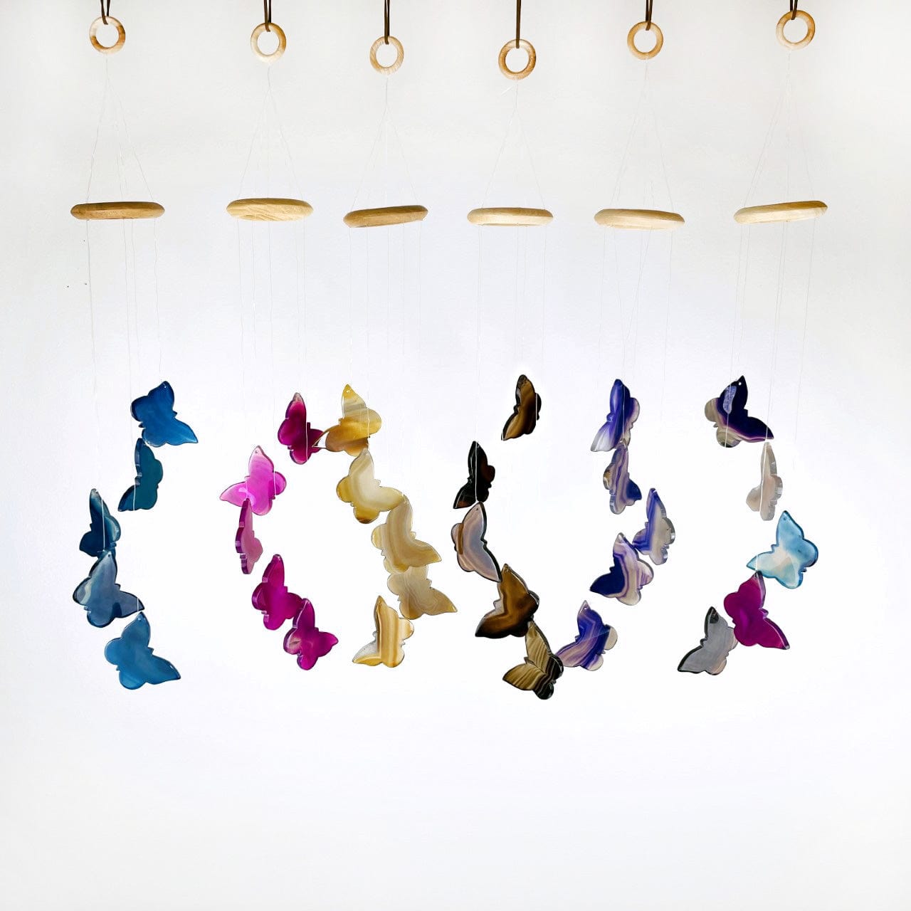 all colors of agate butterfly wind chimes hanging in a row