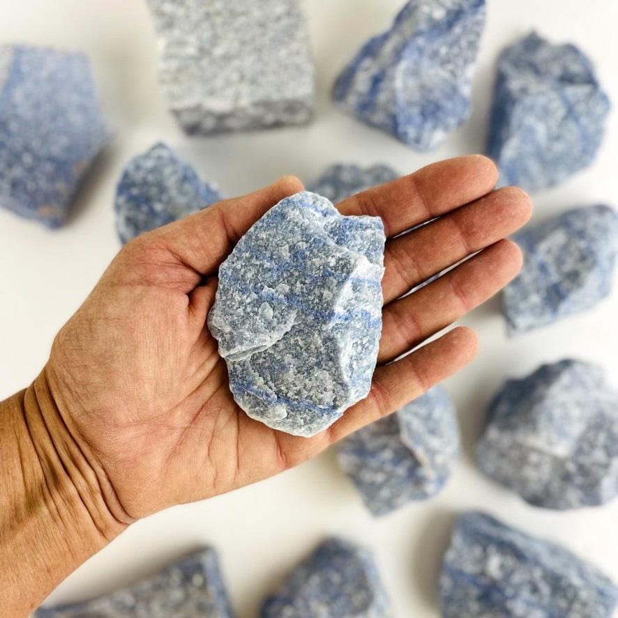 blue quartz rough stone in hand for size reference 