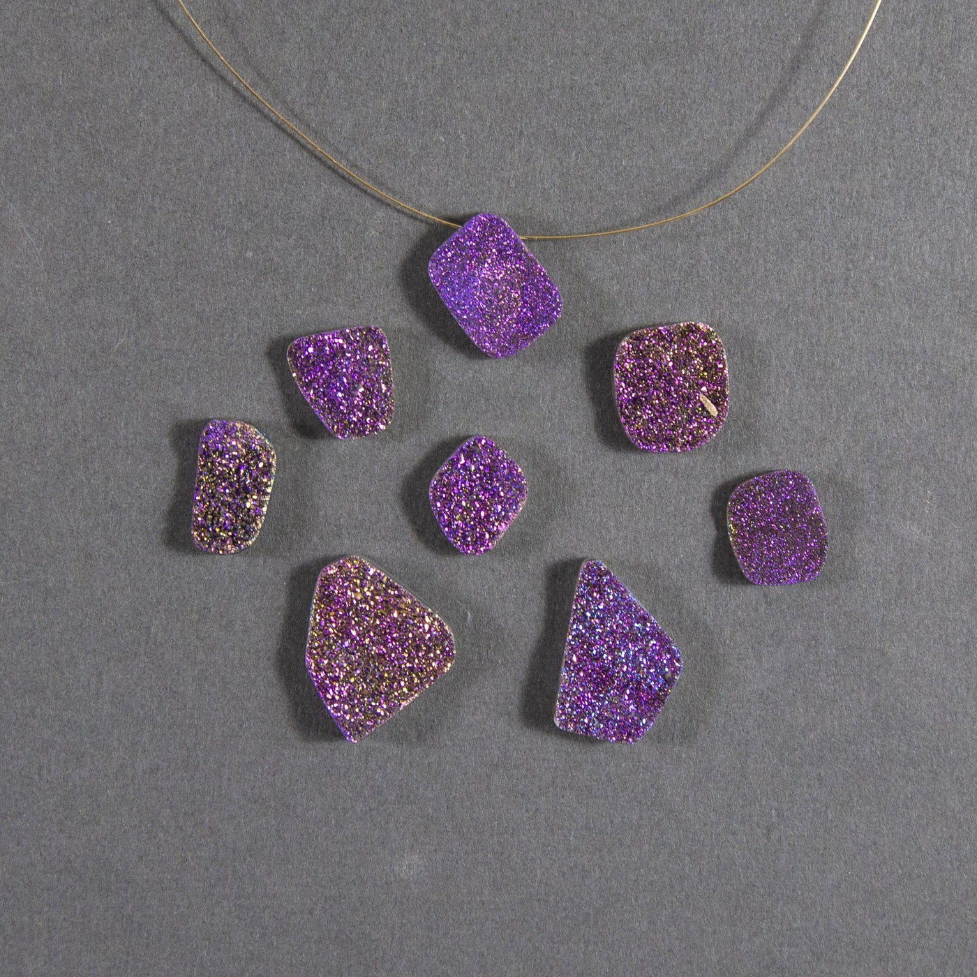 purple druzy beads displayed with a wire through hole and up close to view various colors textures shapes sizes