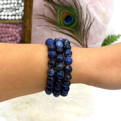 close up of three sodalite round bead bracelets on wrist for size reference and possible variations