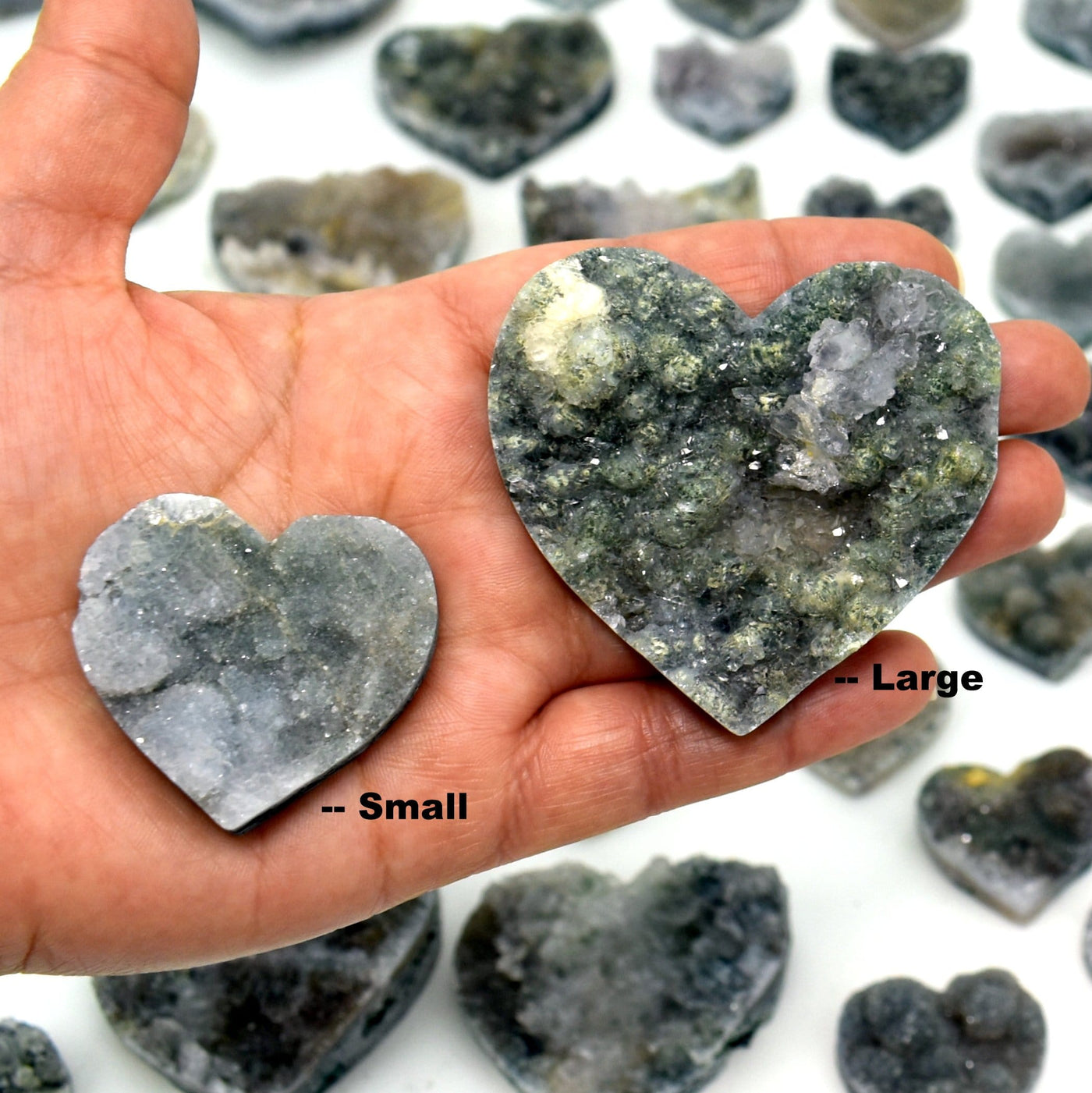 hand holding 1 small and 1 large Amethyst Flower Heart