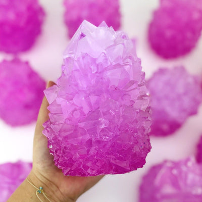 pink salt crystal formation in hand for size reference