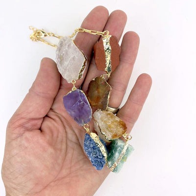 Chakra Necklace - 7 Rough Stones on large Link Chain in a hand for size reference