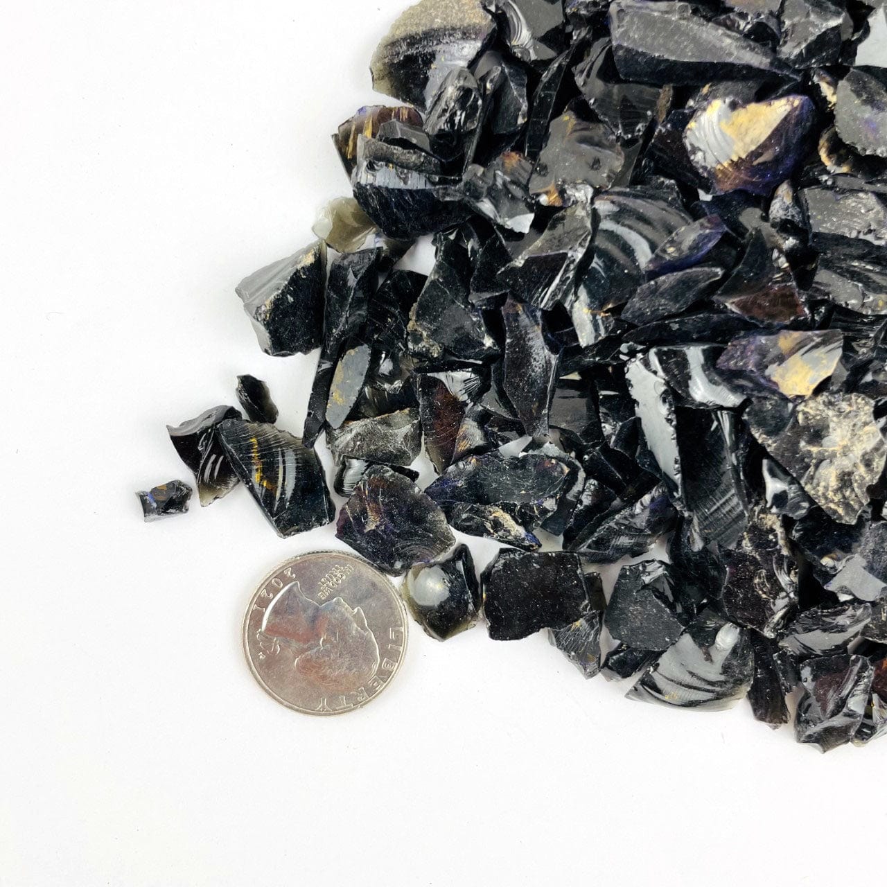 Black Obsidian Stones next to a quarter for sizing
