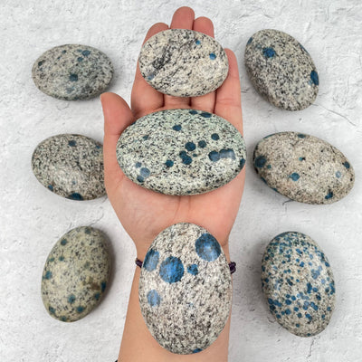 K2 Granite and Azurite Palm Stones in hand for size reference 