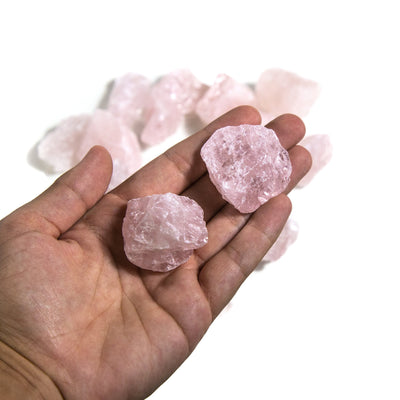 rough rose quartz stones in hand for size reference 