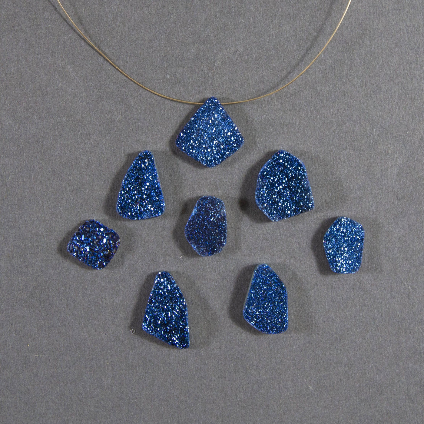 mystic blue druzy beads displayed with a wire through hole and up close to view various colors textures shapes sizes