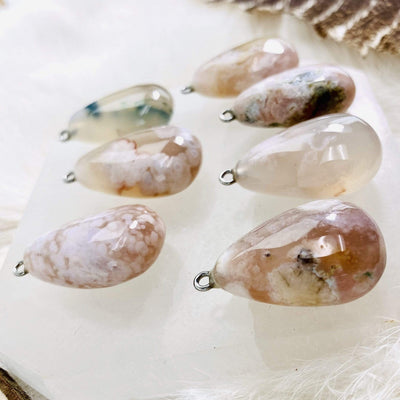 Side view of Flower Agate Tumbled Pendants with Silver Bail showing the thickness. 