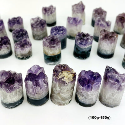 A variety of size 100gram - 150gram amethyst cores on a white background.