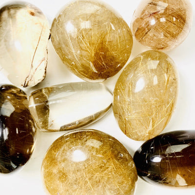 Rutilated Quartz Polished Lens showing assorted shade of  coloring, from brown to golden