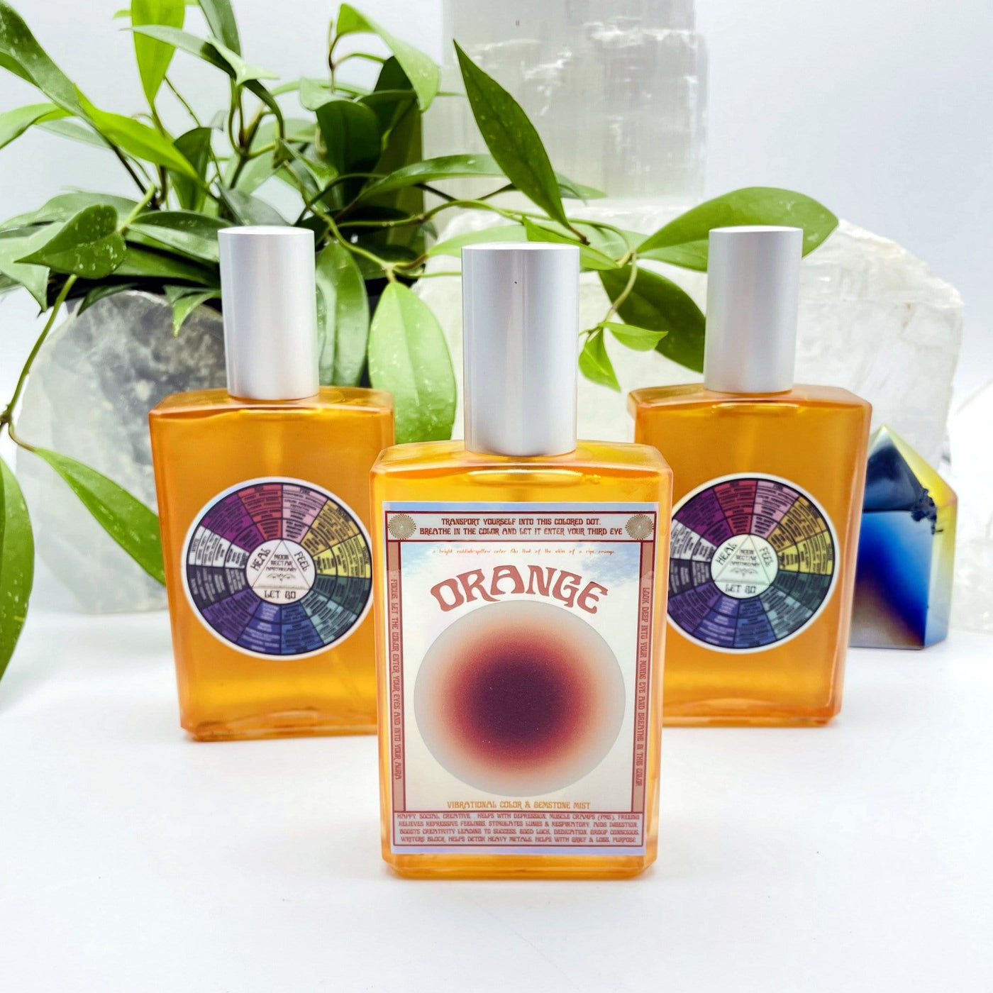 3 bottles of Gemstone Mist - Orange Vibrational Color with decorations in the background