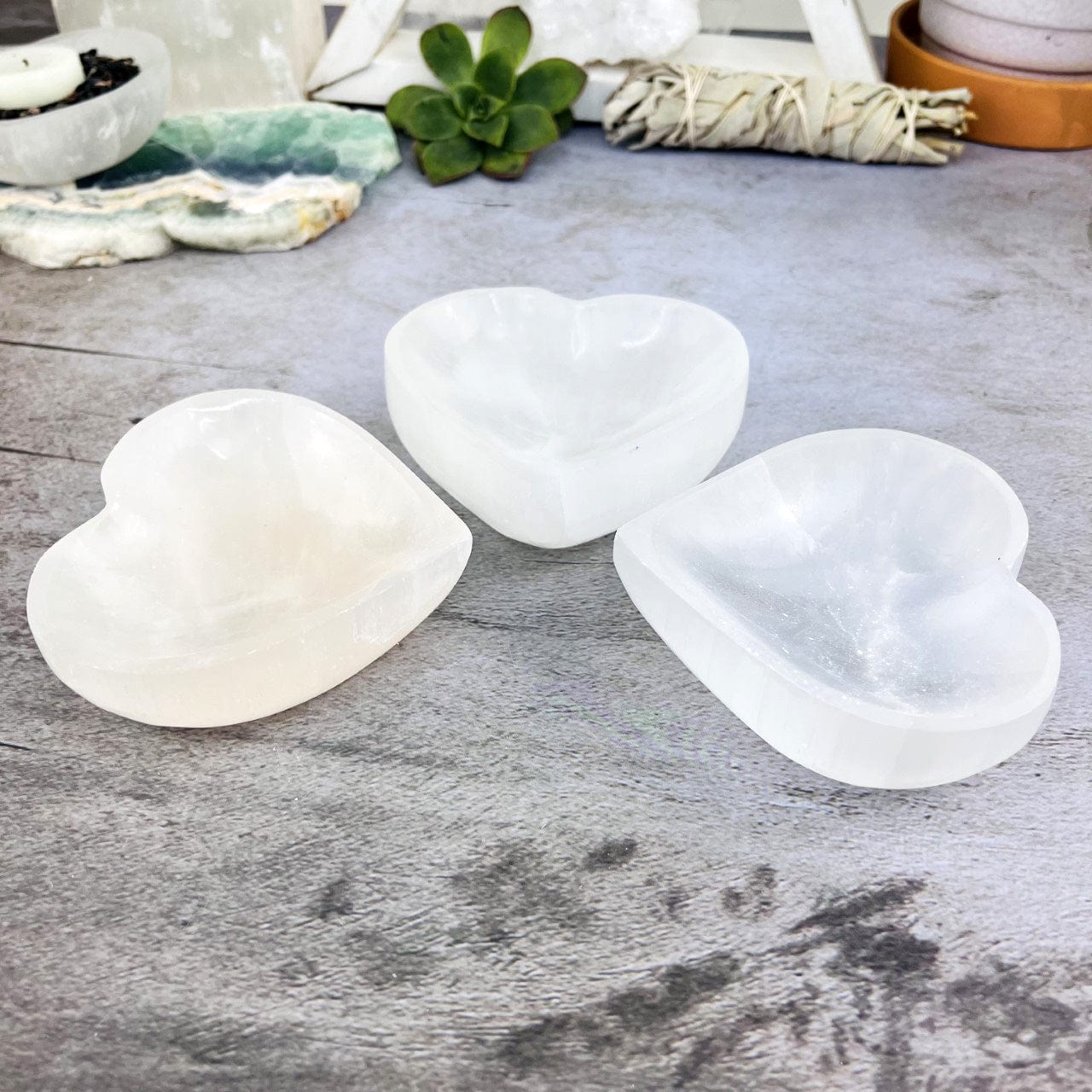 3 Selenite Heart Bowls on a table