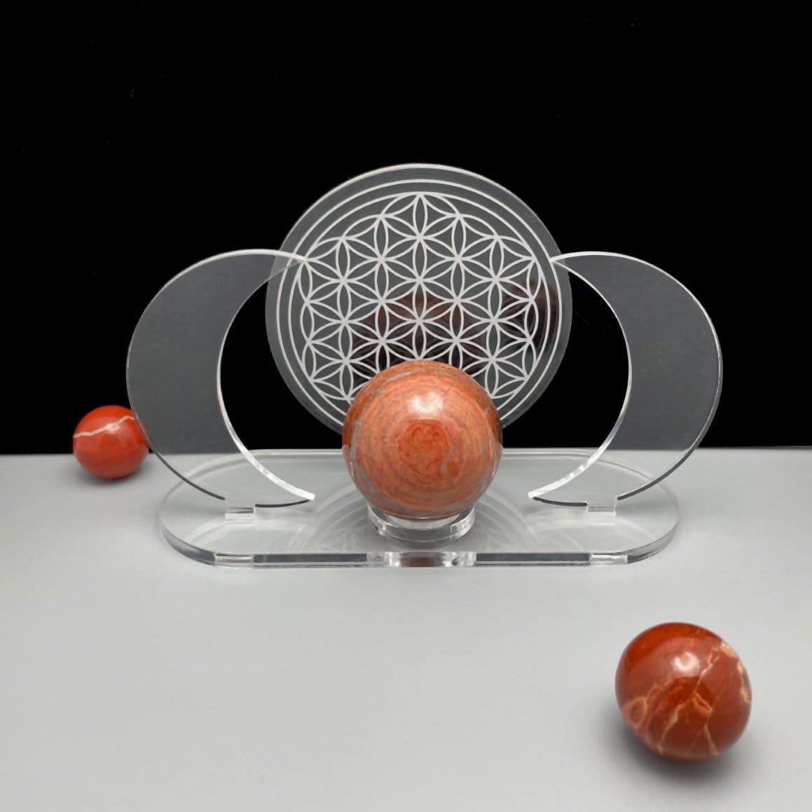 Acrylic Sphere Holder - Crescent Moons with Flower of Life displayed with a front view surrounded with a few spheres.