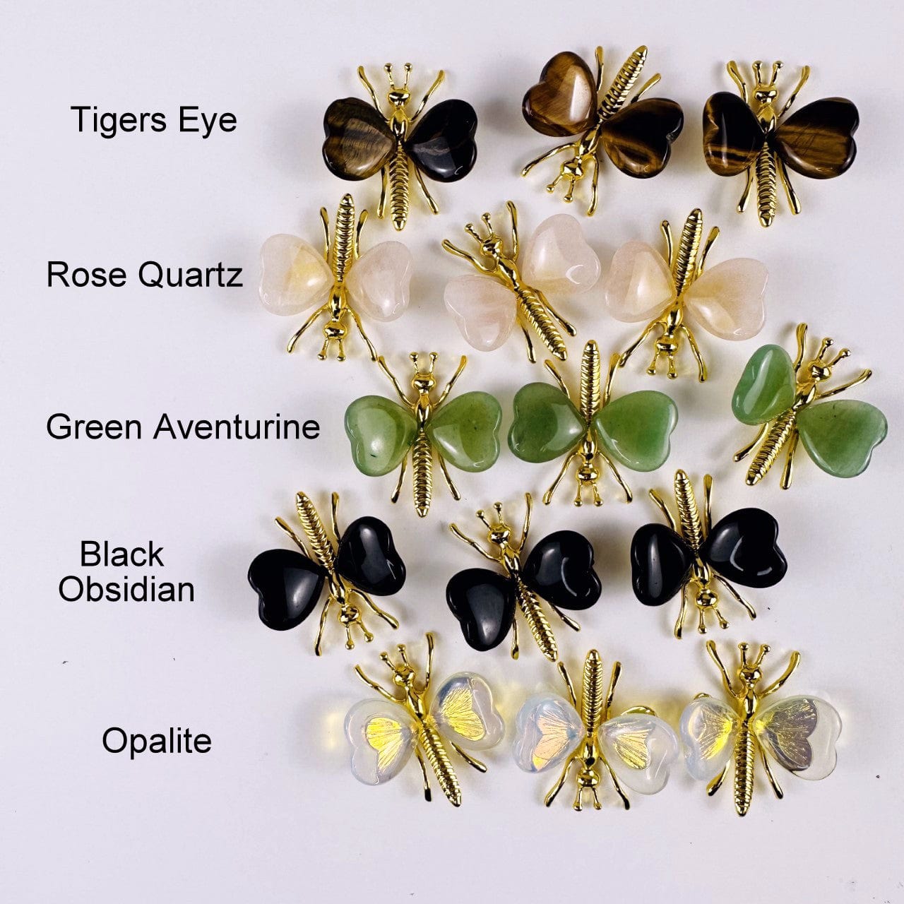 Gemstone Butterflies with Gold Tone Body on a table showing the assorted stones we carry and the stone name next to it