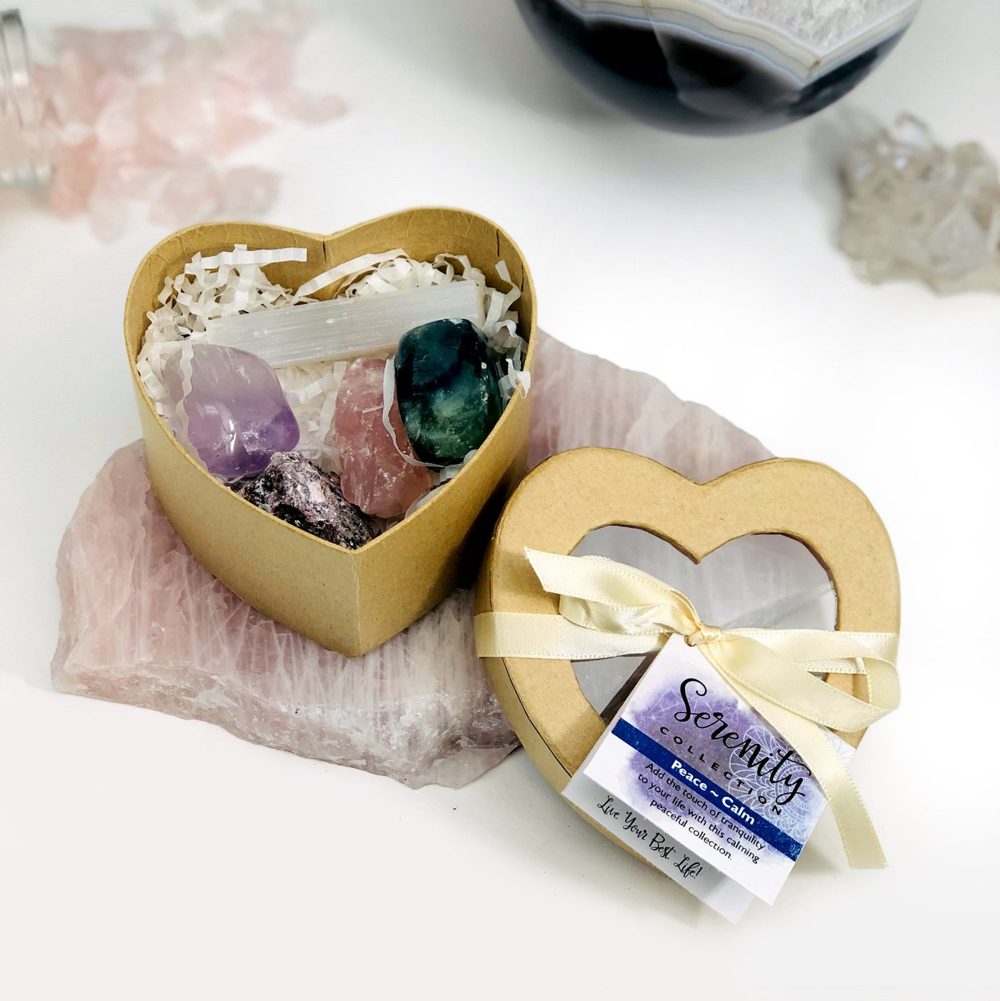 serenity heart box with selenite, amethyst, rose quartz, fluorite, and lepidolite with other crystals in the background