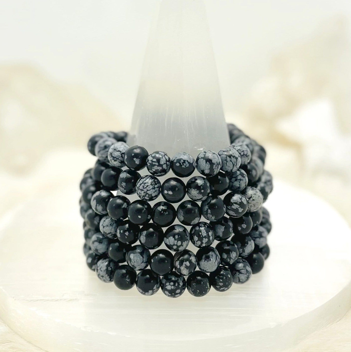 six snowflake jasper round bead bracelets stacked on display