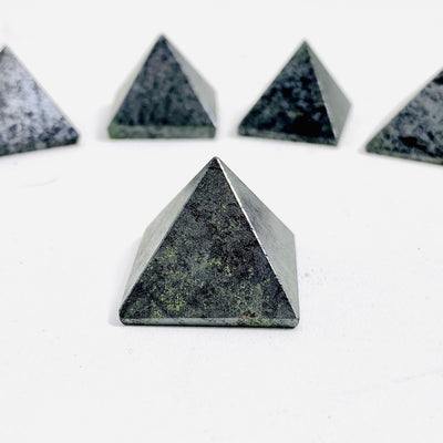hematite pyramid placed in front of multiple to show close up of design