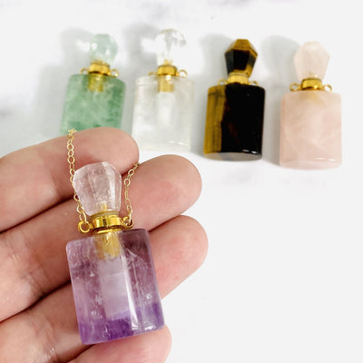 gemstone essential oil square bottle pendant in hand for size reference