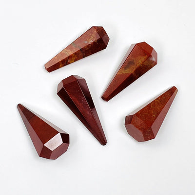 5 Red Jasper Pendulum Points scattered on white background