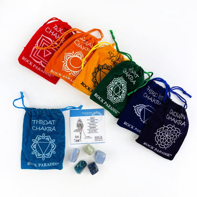 The Light Blue Throat Chakra set opened up with the information card and stones beside it.  The other pouches of stones lined up behind