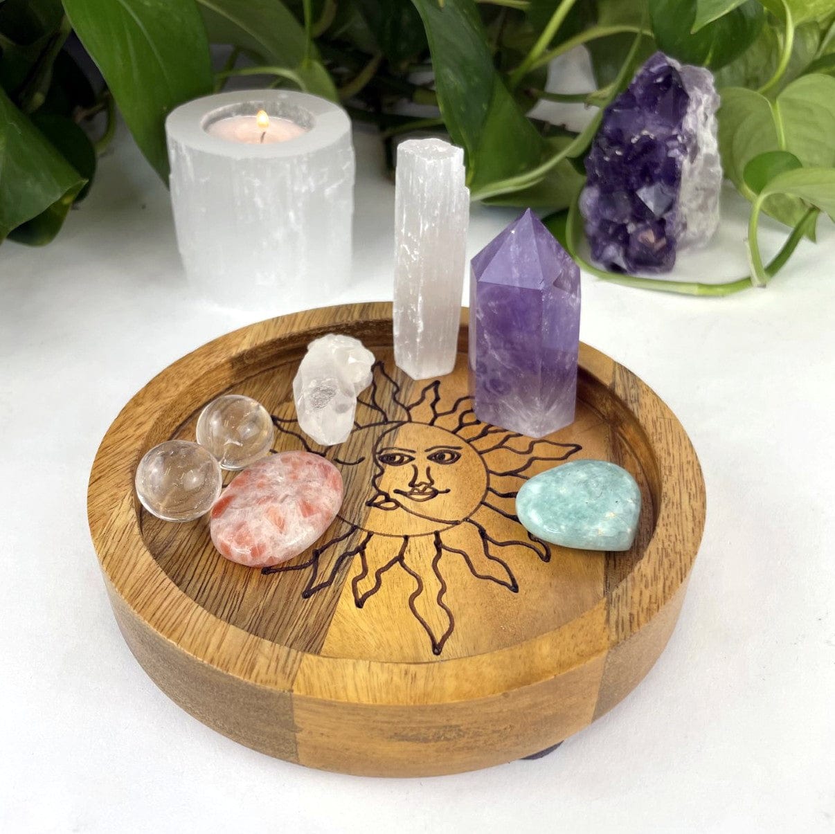 small Round Mango wood tray with a sun and moon etched in black inside.  Assorted crystals are placed in the tray for decoration