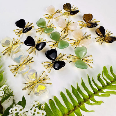 Gemstone Butterflies with Gold Tone Body on a table showing the assorted stones we carry from a side angle