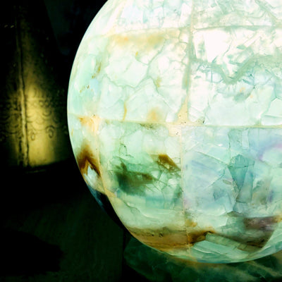 Rainbow Fluorite Sphere Lamp lit up in dark room