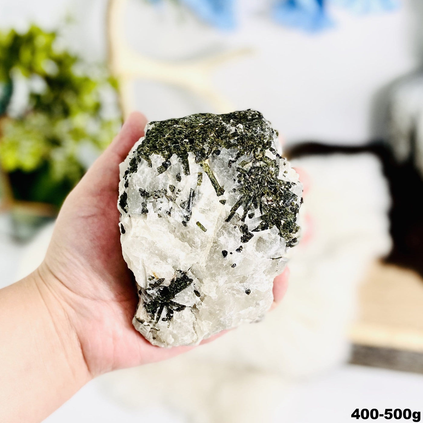 1 piece of Epidote In Quartz Chunk in hand showing the weight 400 to 500 grams on white background.