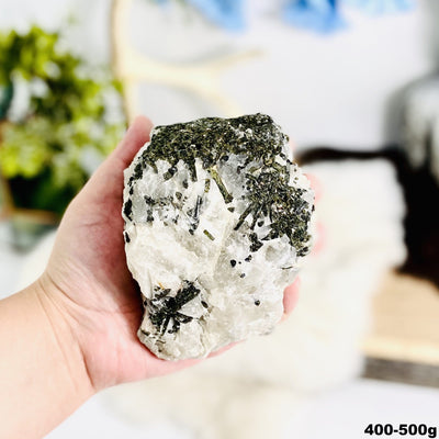 1 piece of Epidote In Quartz Chunk in hand showing the weight 400 to 500 grams on white background.
