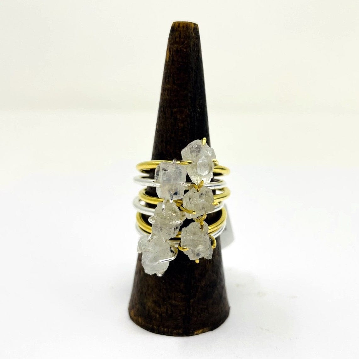 gold and silver moonstone rings stacked on a a wood ring holder with a white background