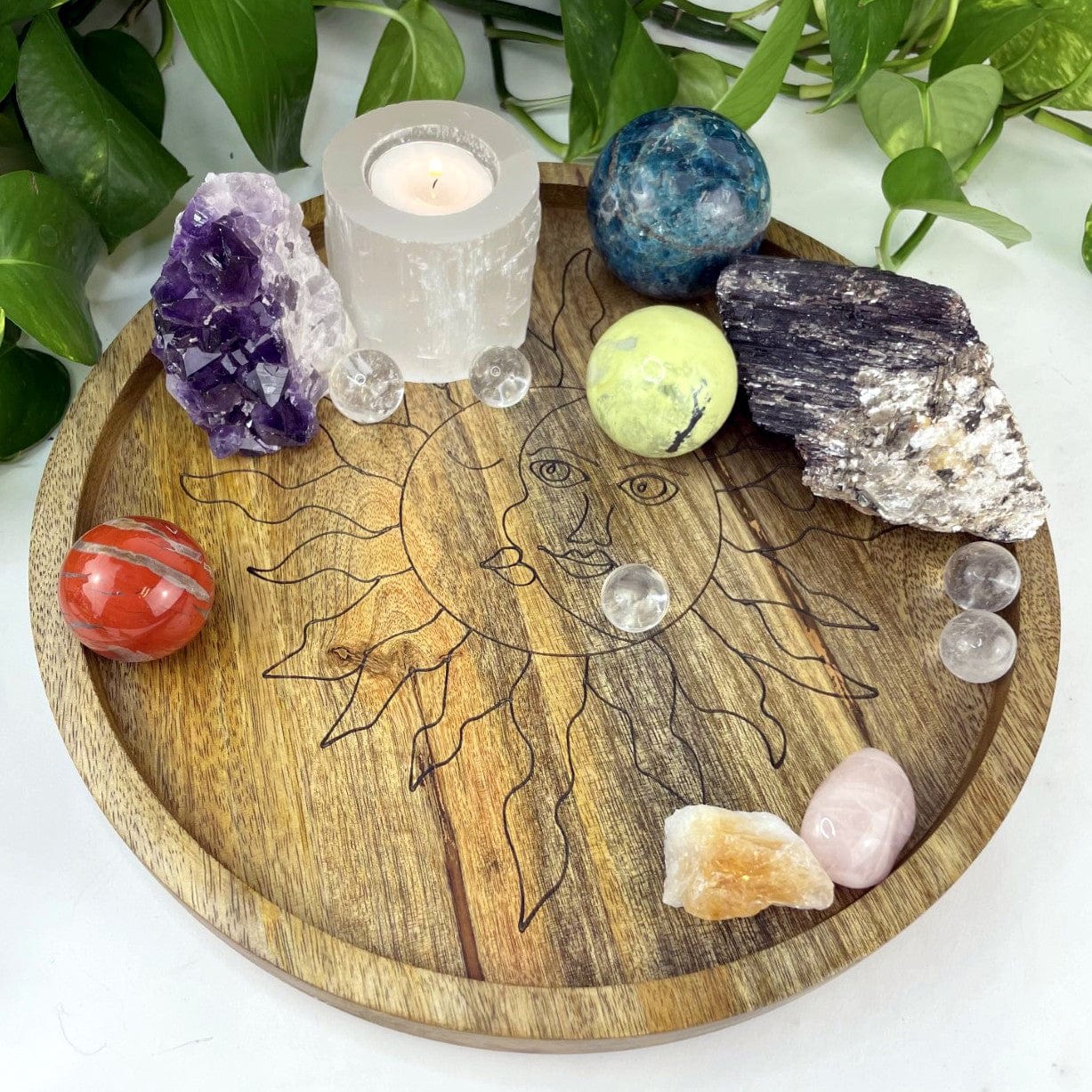 large ound Mango wood tray with a sun and moon etched in black inside.  Assorted crystals are placed in the tray for decoration