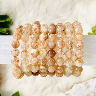 multiple Golden Sunstone Round Bead Bracelets displayed to show various colors inclusions sheen and overall characteristics