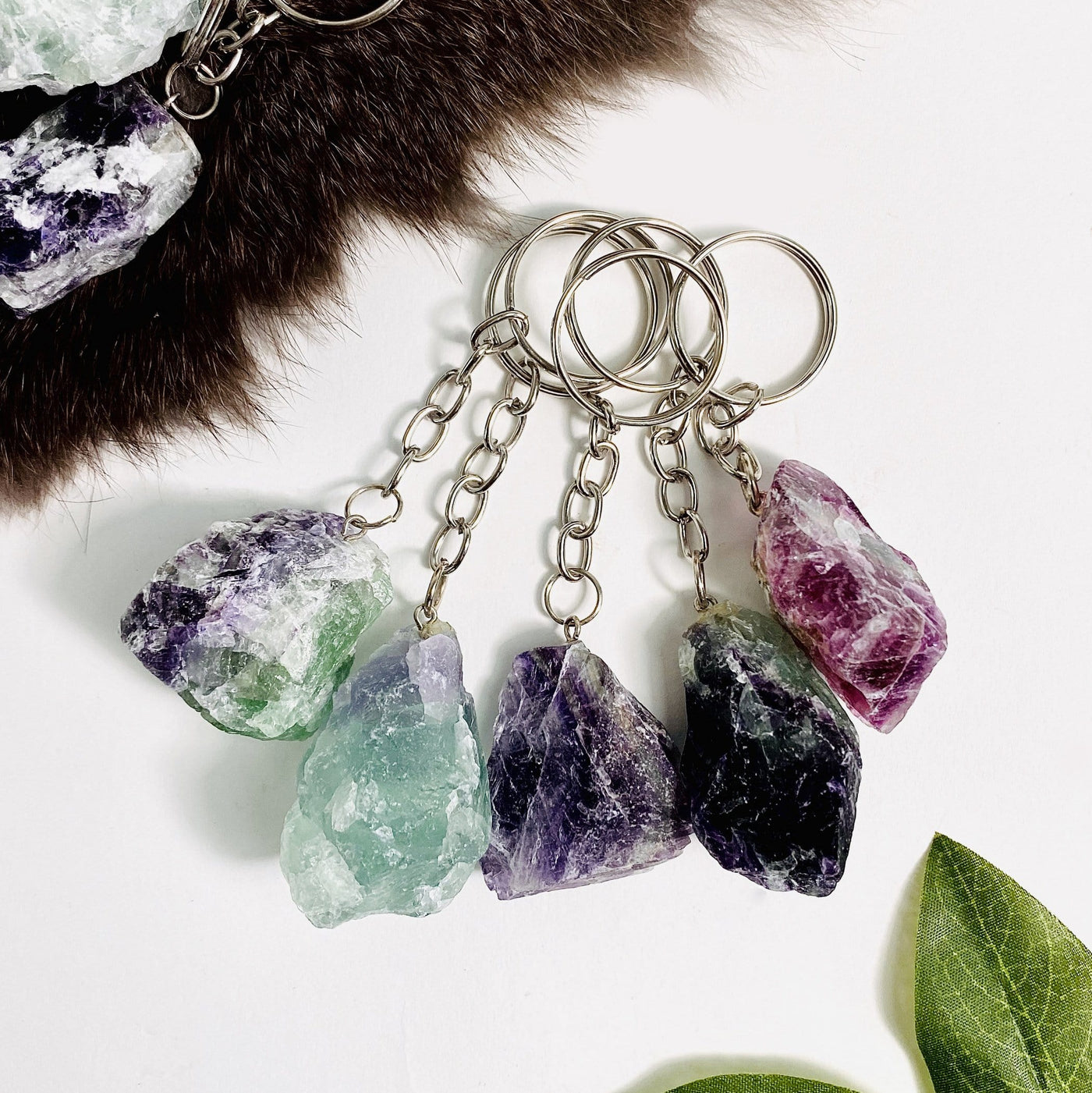 5 Rainbow Fluorite Silver Toned Key-Chains with various decorations on white background