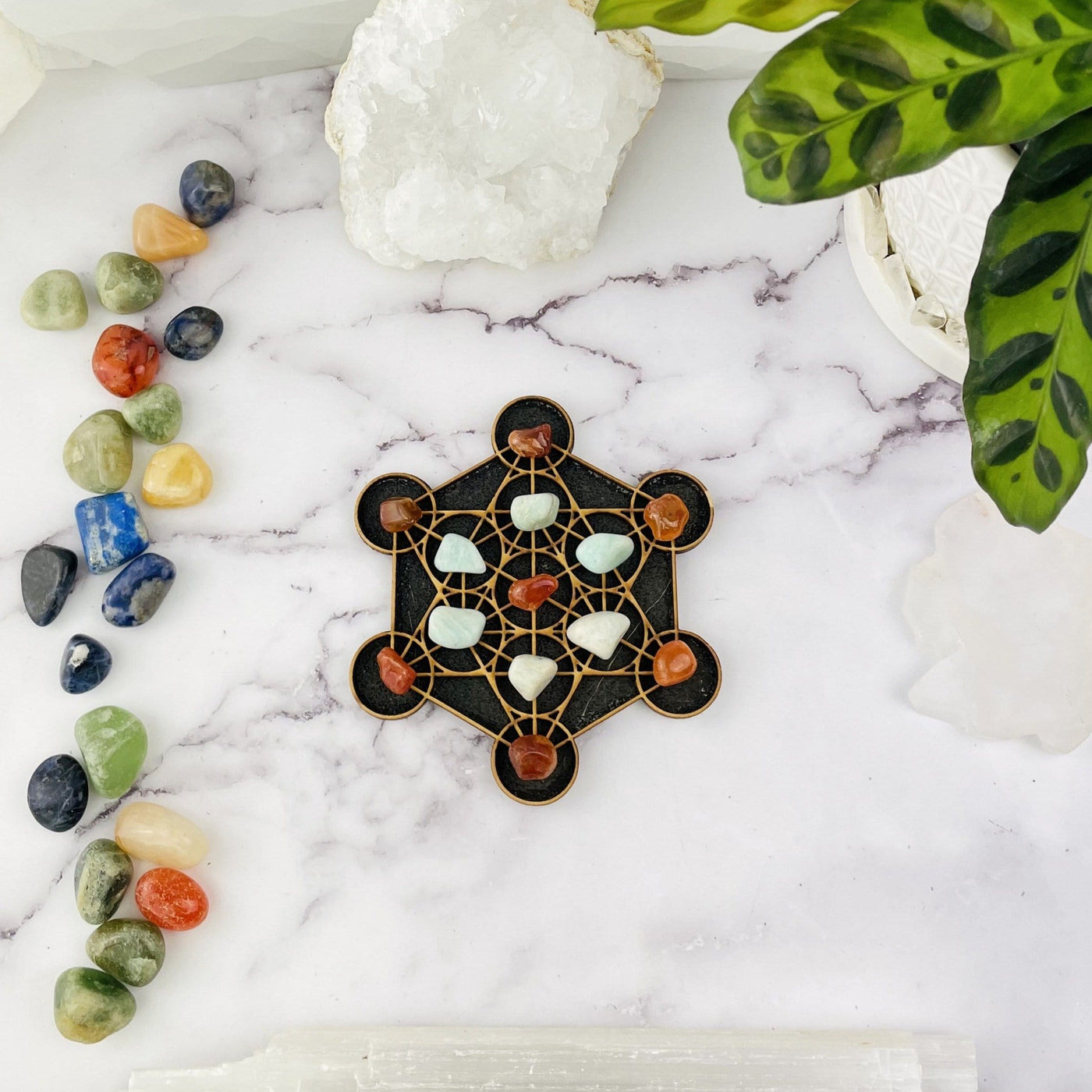 Metatron Cube mini Crystal Grid - on a table with stones on it and stones scattered next to it