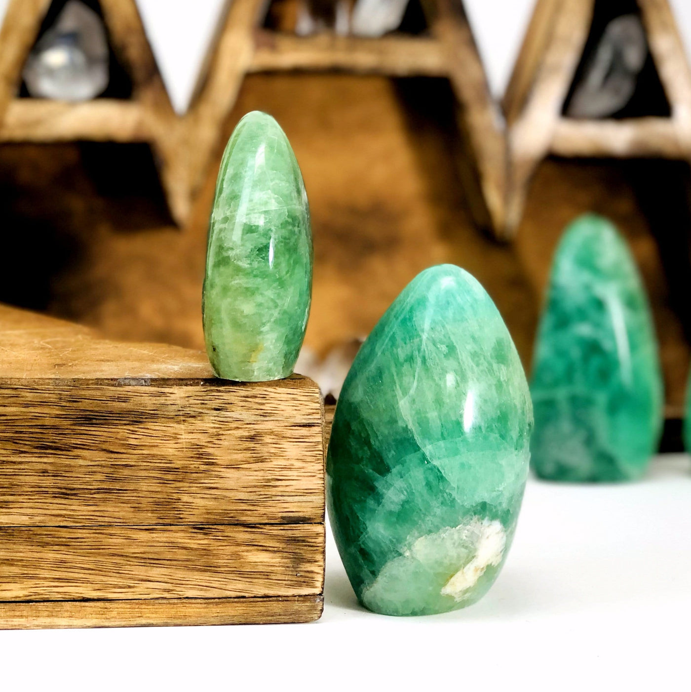 2 Green Fluorite Polished Cut Bases with another blurred in the background