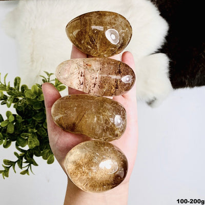 4 Rutilated Quartz Polished Lens' in a hand showing size of the stock of 100-200g