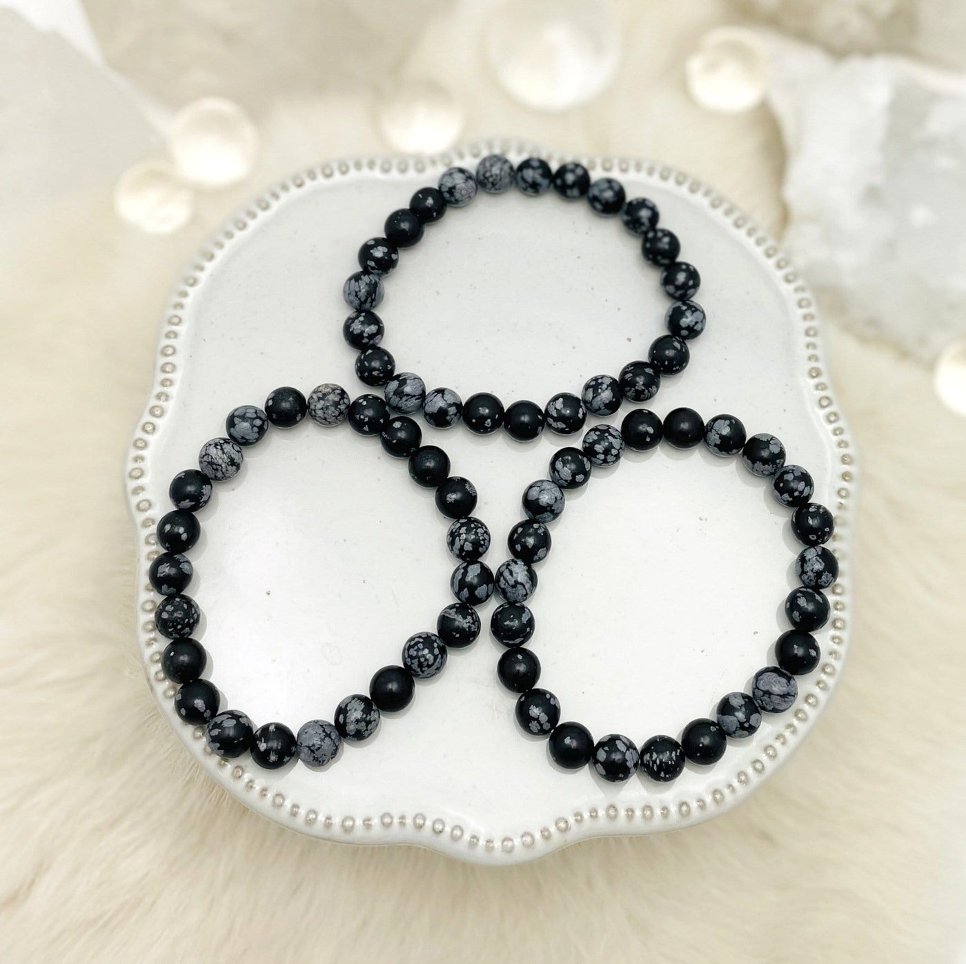 overhead view of three snowflake jasper round bead bracelets on display