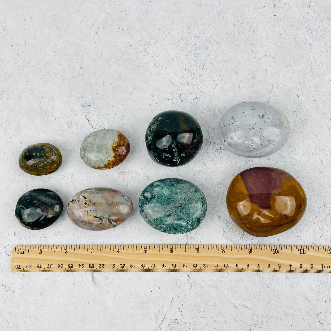 Ocean Jasper Palm Stones displayed next to a ruler for size reference 