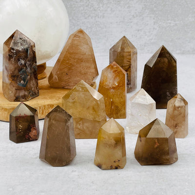 multiple rutilated quartz points displayed to show the differences in the sizes and color shades 