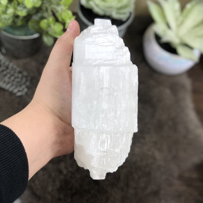 side view of selenite log candle holder in hand for thickness
