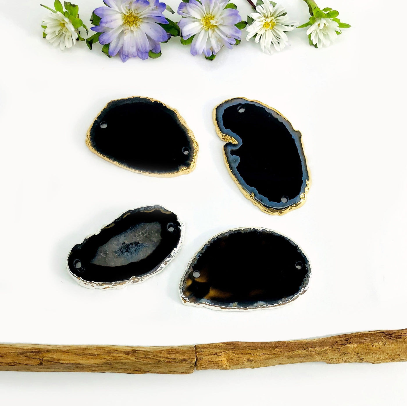 Picture of or black silver and gold plated edge agate slice being displayed on a white back ground.