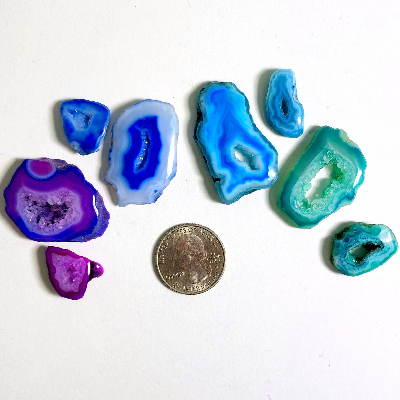 Multiple Agate Druzy Small Slices (RK140B21) next to a quarter for size reference.