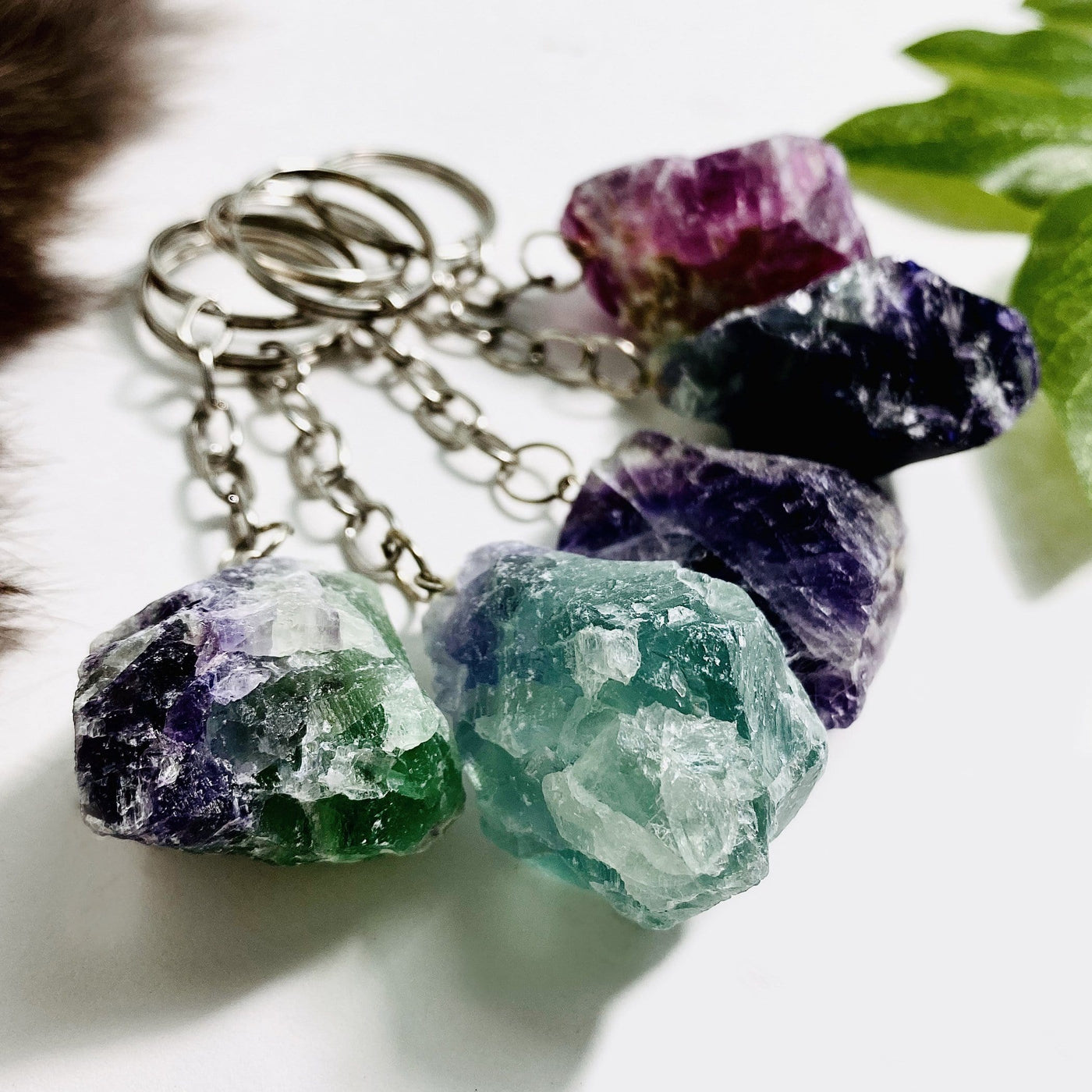 Up close shot of Rainbow Fluorite Silver Toned Key-Chains on white background