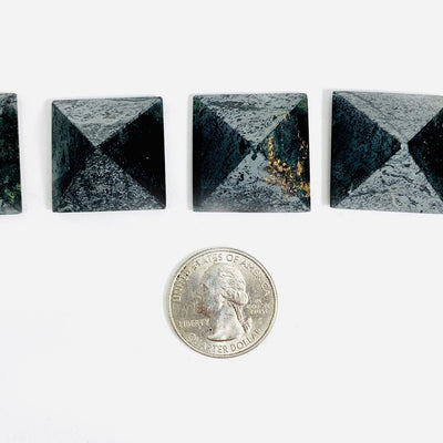 multiple hematite pyramids shown with a quarter in picture to show difference in size and design