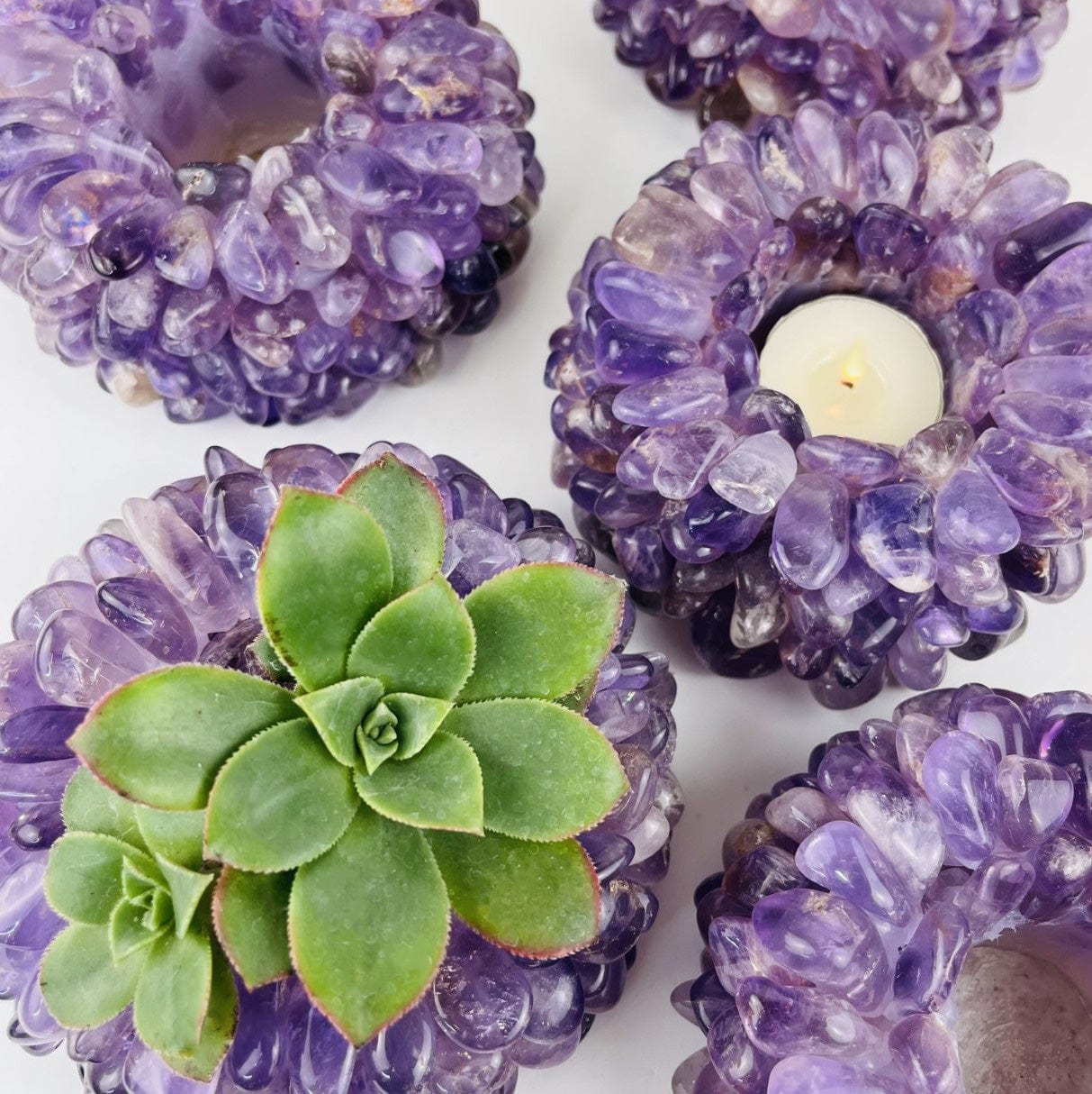 amethyst Tumbled Crystal Candle Holder one with a candle and one with a succulent