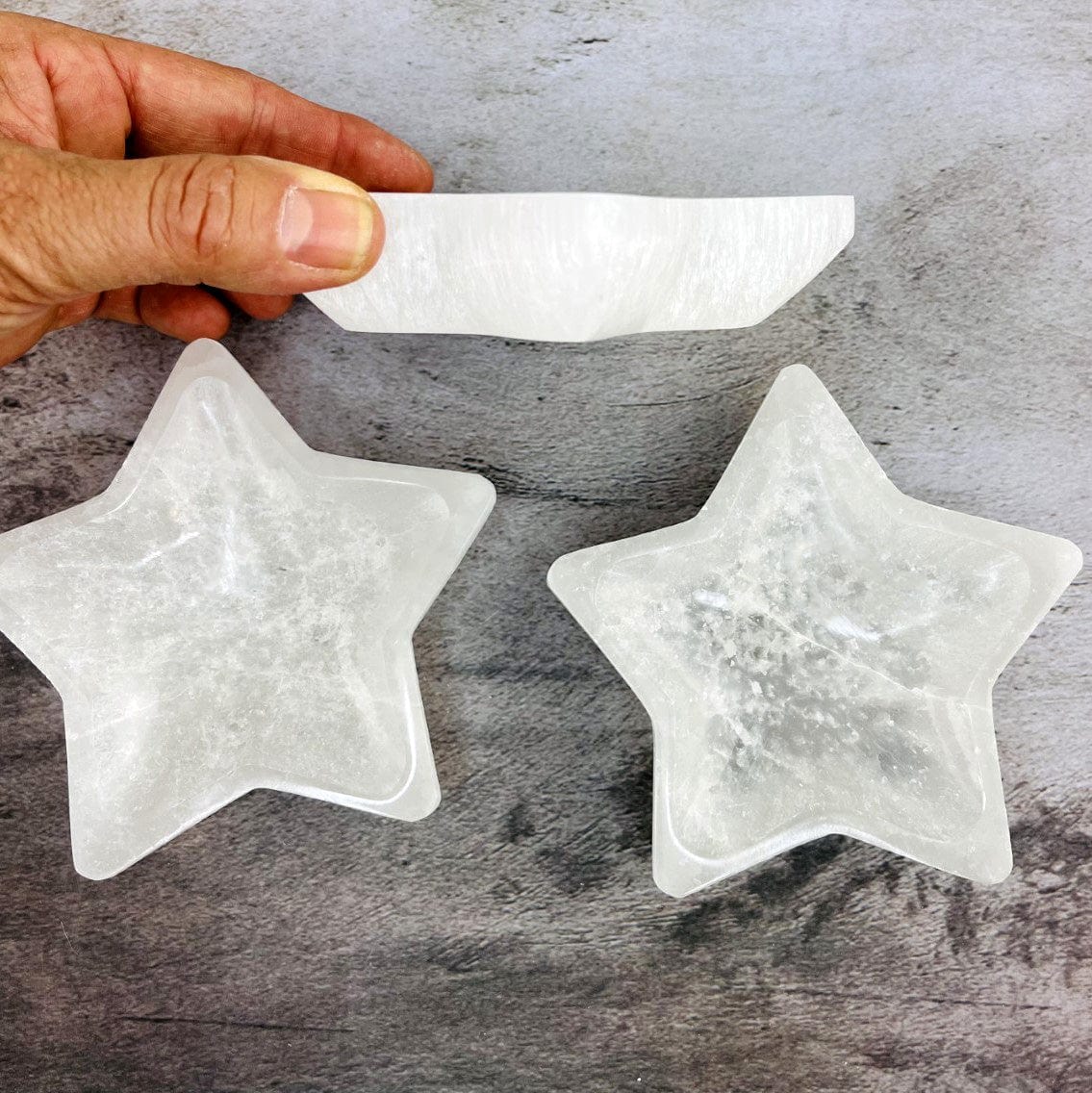 Selenite Star Bowl from side view in a hand for sizing