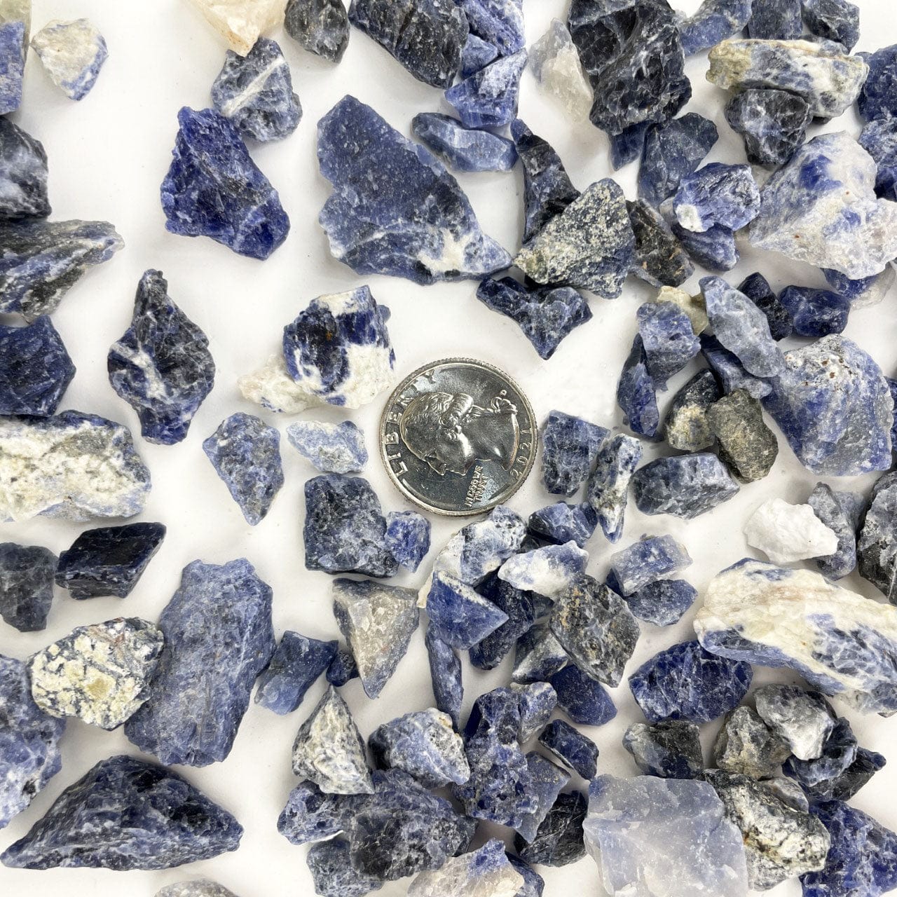 Sodalite Stones on a table with a quarter for size