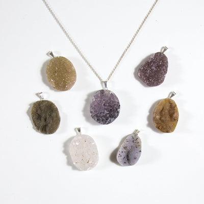 7 druzy cabochon pendants, one on a silver necklace chain
